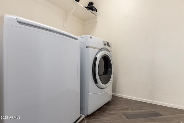 washroom featuring laundry area, baseboards, dark wood finished floors, and washer / dryer