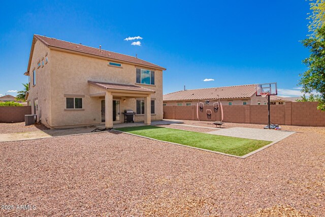 back of house with a fenced backyard, cooling unit, a patio, and stucco siding