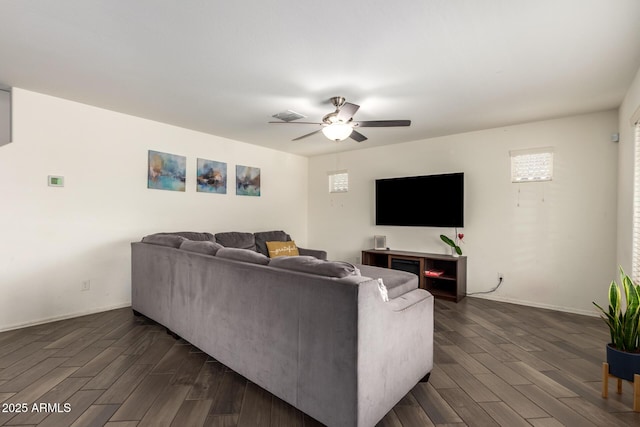 living room featuring ceiling fan, baseboards, visible vents, and dark wood finished floors