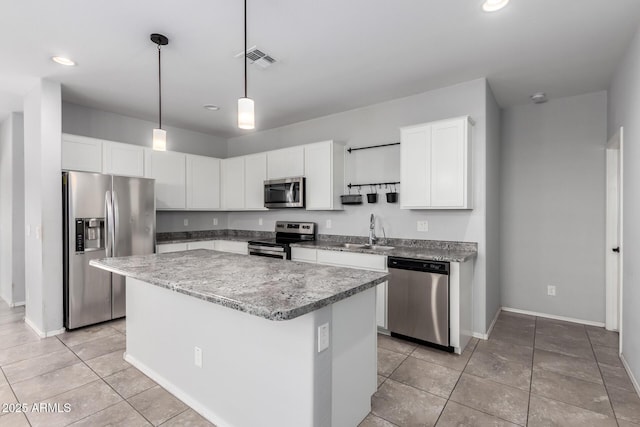 11505 W Boca Raton Rd, El Mirage, AZ 85335 - kitchen with stainless steel appliances, a sink, a center island, baseboards, and white cabinetry