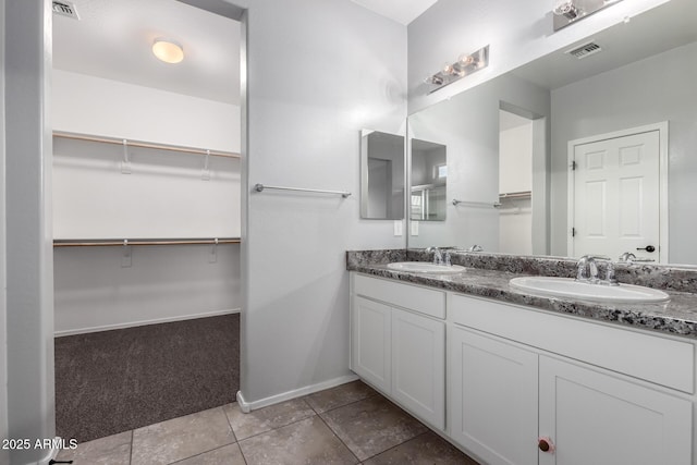 11505 W Boca Raton Rd, El Mirage, AZ 85335 - full bathroom with a walk in closet, baseboards, double vanity, and tile patterned floors