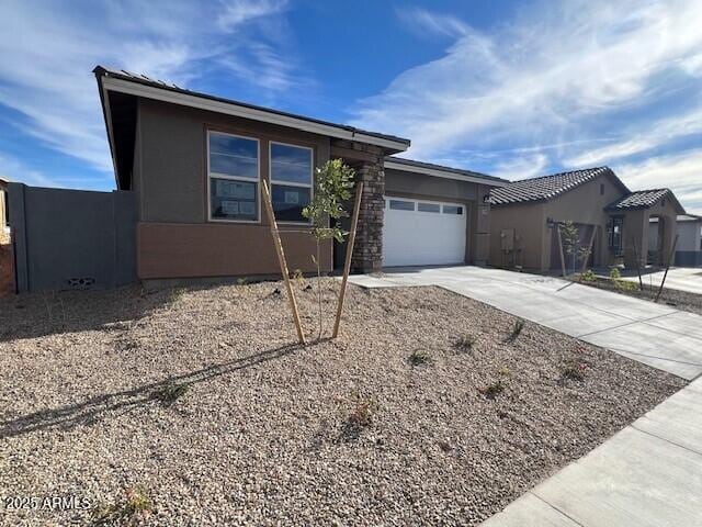 view of front of house with concrete driveway, a garage, and stucco siding