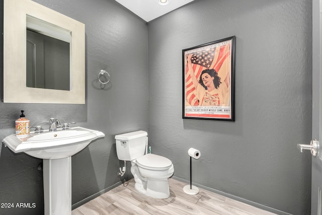 bathroom with hardwood / wood-style flooring, sink, and toilet