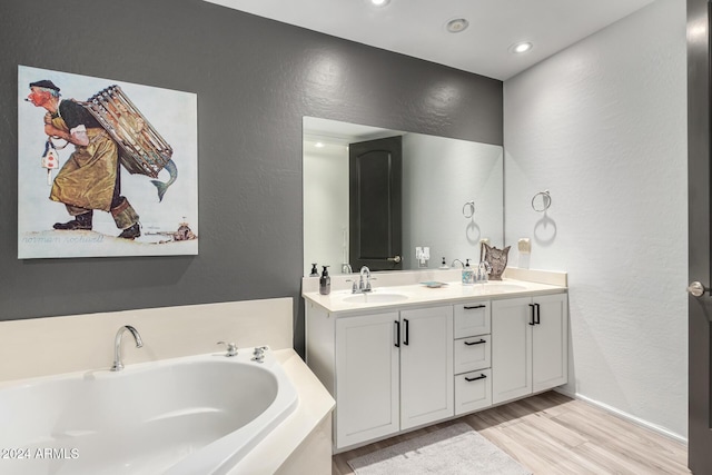 bathroom featuring hardwood / wood-style floors, vanity, and a tub to relax in