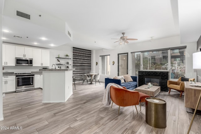 living room with ceiling fan and sink