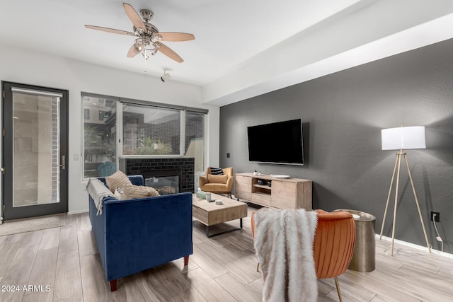 living room featuring a tile fireplace and ceiling fan