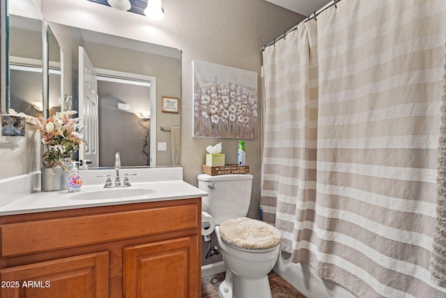 bathroom with toilet, vanity, a textured wall, and curtained shower