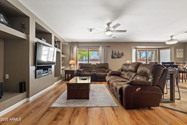 living area with wood finished floors, ceiling fan, and baseboards