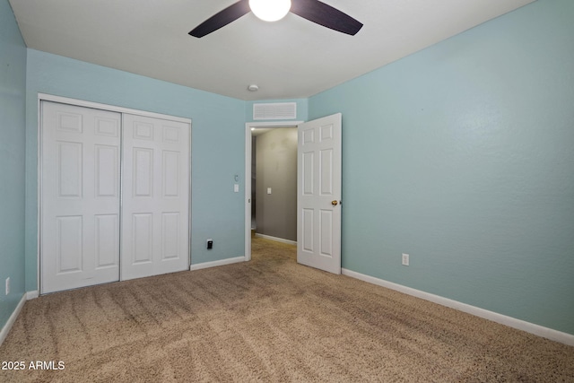 unfurnished bedroom with carpet, a closet, baseboards, and ceiling fan