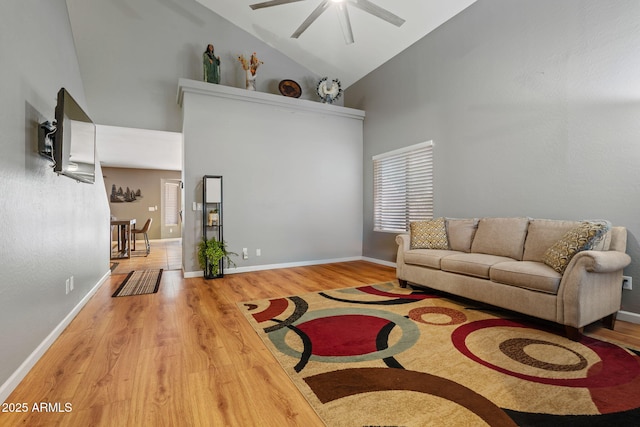 living area with high vaulted ceiling, a ceiling fan, wood finished floors, and baseboards