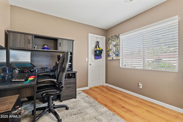 office area with baseboards and light wood finished floors