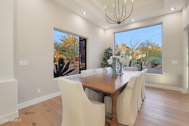 dining space with a chandelier and light hardwood / wood-style flooring