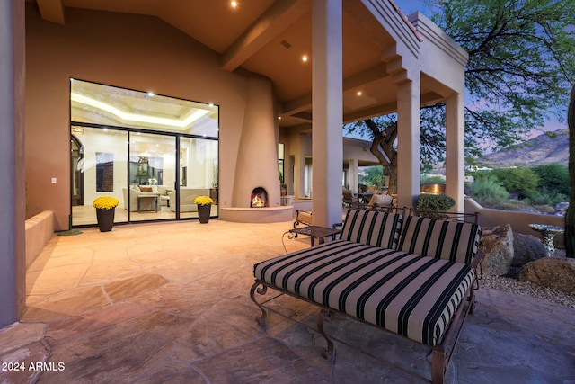 patio terrace at dusk with an outdoor living space with a fireplace