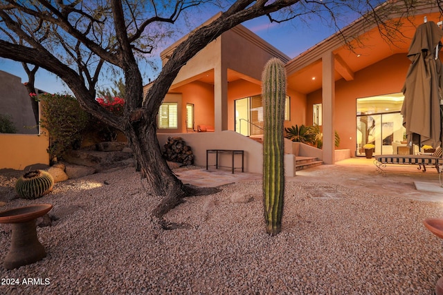 back house at dusk with a patio