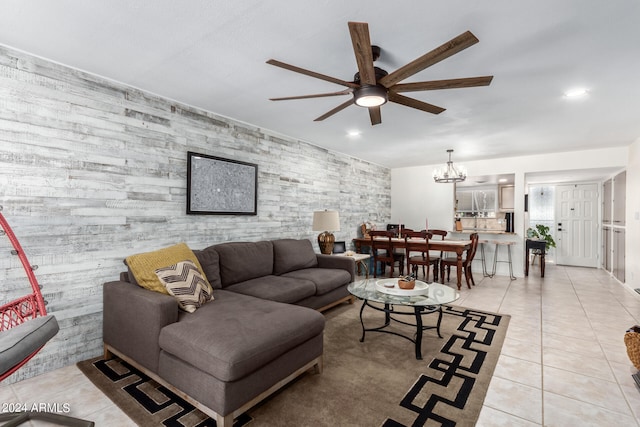 living room with ceiling fan with notable chandelier and light tile patterned floors