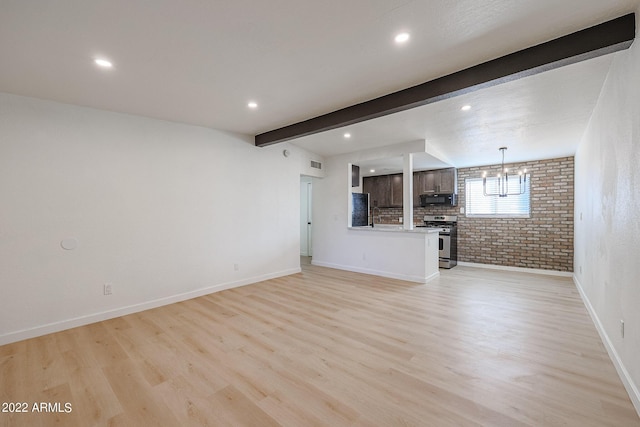 unfurnished living room featuring brick wall, baseboards, beamed ceiling, light wood-style flooring, and a notable chandelier