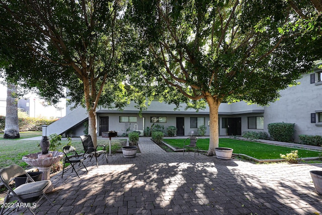 exterior space featuring stucco siding, a patio, and a lawn