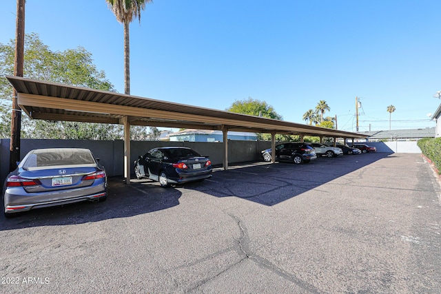 covered parking lot featuring fence