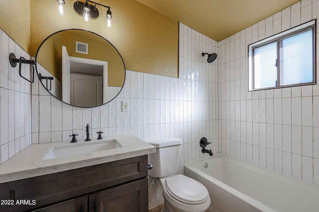 bathroom with vanity, visible vents, shower / washtub combination, tile walls, and toilet