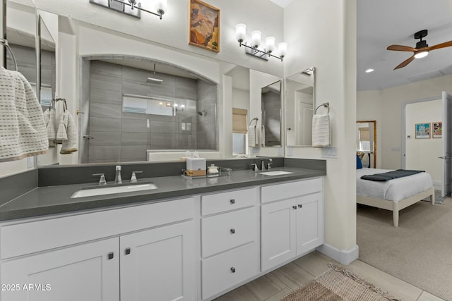 bathroom with ceiling fan, vanity, and a tile shower