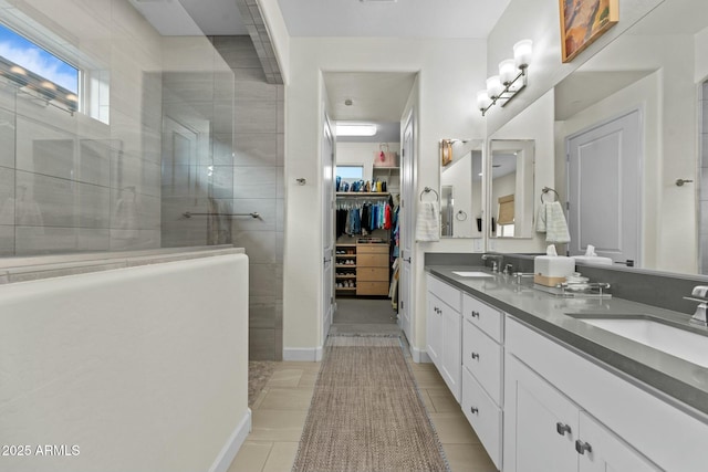 bathroom featuring vanity, tile patterned floors, and a tile shower