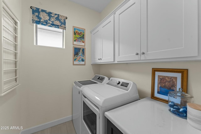 washroom with light tile patterned floors, cabinets, and washing machine and clothes dryer