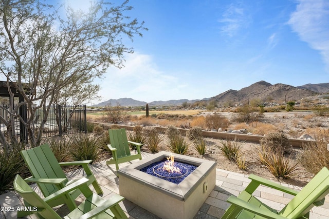 view of patio / terrace with a mountain view and an outdoor fire pit