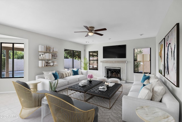 living room with ceiling fan, a wealth of natural light, a high end fireplace, and light tile patterned floors