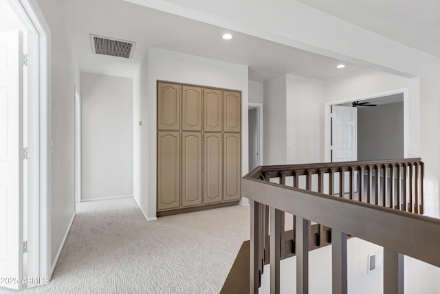 hallway featuring light colored carpet