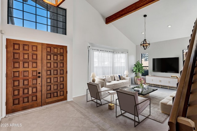 tiled living room featuring a chandelier, a high ceiling, and beamed ceiling