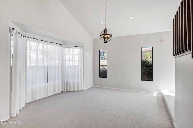 unfurnished room with light colored carpet, a chandelier, and high vaulted ceiling