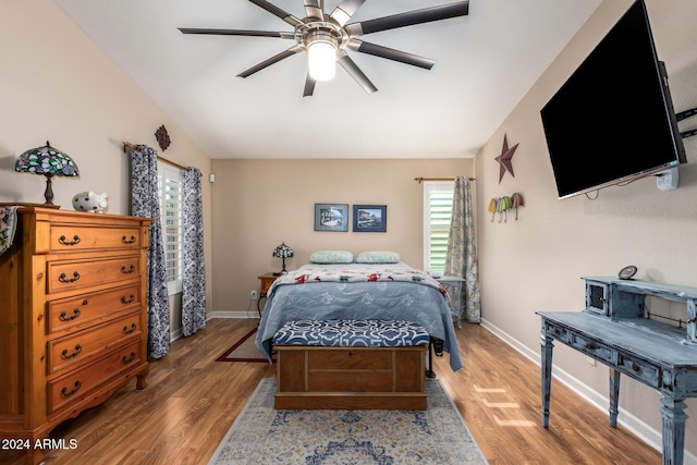 bedroom with ceiling fan, wood-type flooring, and vaulted ceiling