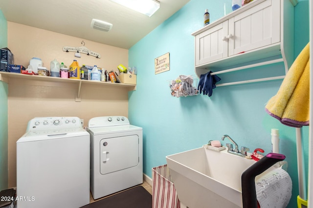 laundry room with cabinets, washing machine and dryer, and sink