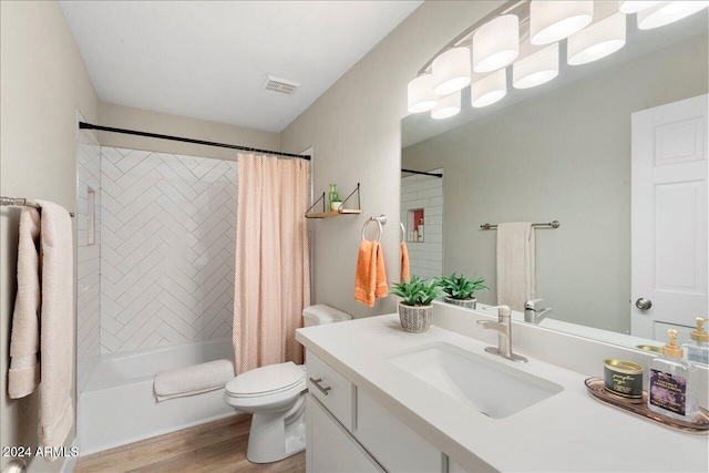 full bathroom featuring hardwood / wood-style floors, vanity, toilet, and shower / bath combo with shower curtain