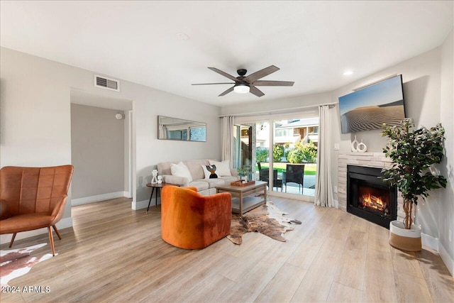 living room with ceiling fan and light hardwood / wood-style flooring