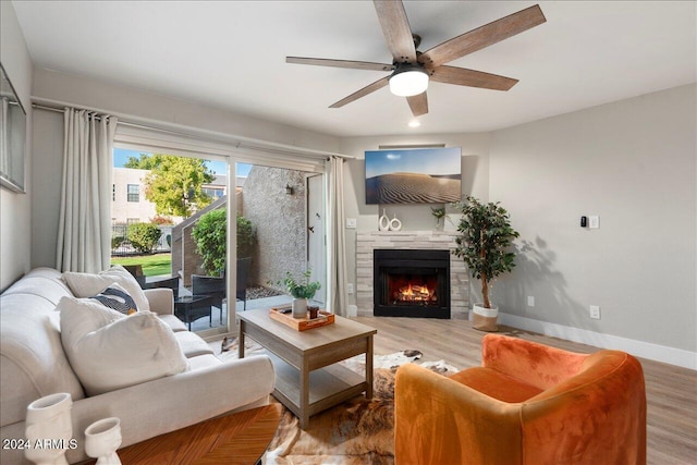 living room with hardwood / wood-style flooring, ceiling fan, and a fireplace