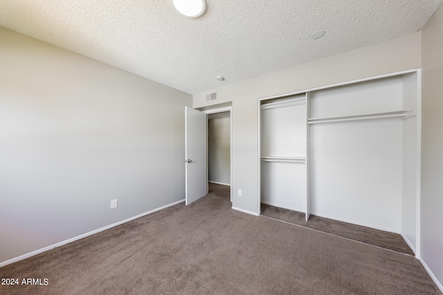 unfurnished bedroom with a textured ceiling, a closet, and carpet floors