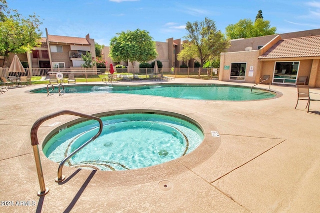 view of swimming pool featuring a community hot tub and a patio