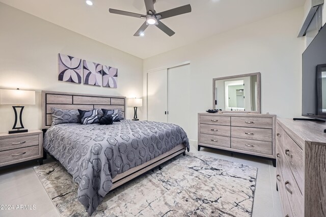 tiled bedroom with ceiling fan, a closet, and vaulted ceiling