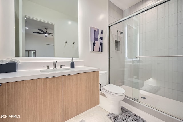 bathroom with vanity, ceiling fan, tile patterned flooring, toilet, and a shower with shower door