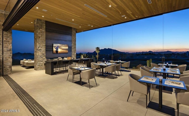 patio terrace at dusk with a mountain view and a bar