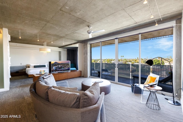 living room with a wall of windows and wood finished floors