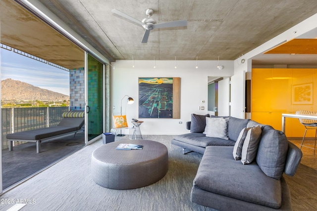 living area with a mountain view and a ceiling fan