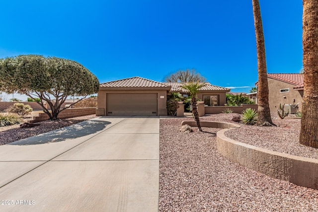 view of front of house featuring stucco siding, an attached garage, driveway, and a tiled roof