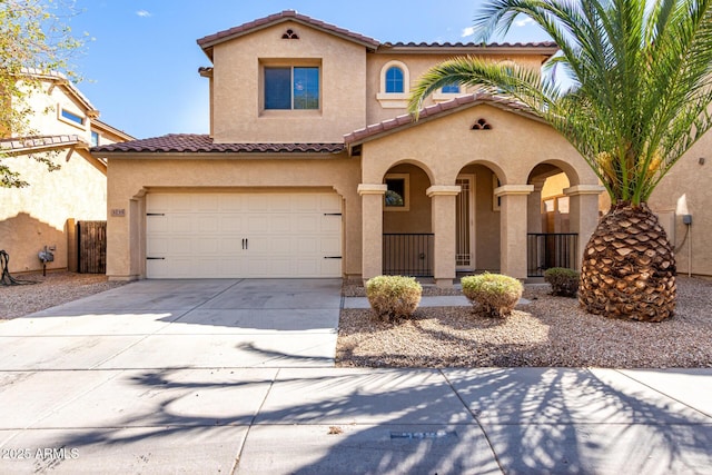 mediterranean / spanish-style house with concrete driveway, an attached garage, a tile roof, and stucco siding