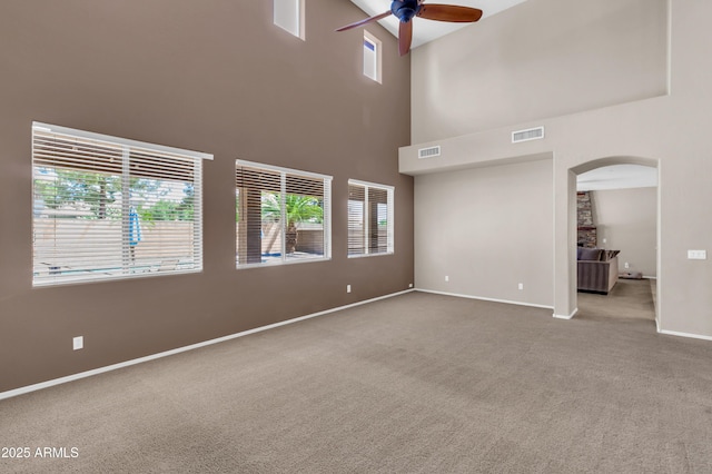 742 E Kingbird Dr, Gilbert, AZ 85297 - empty room featuring a ceiling fan, arched walkways, carpet flooring, and a towering ceiling