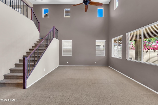 742 E Kingbird Dr, Gilbert, AZ 85297 - unfurnished living room with a towering ceiling, ceiling fan, carpet, and stairway