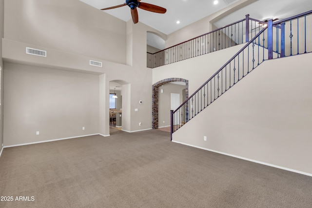 742 E Kingbird Dr, Gilbert, AZ 85297 - unfurnished living room featuring arched walkways, a ceiling fan, carpet floors, a towering ceiling, and recessed lighting