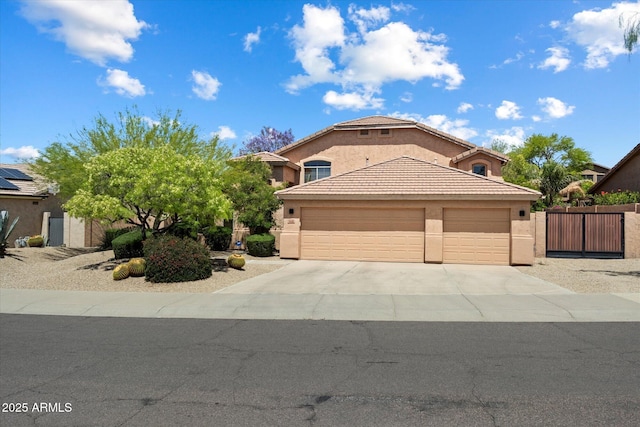 view of front facade with fence, a tile roof, a garage, stucco siding, and driveway