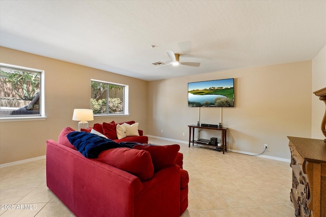 living area featuring light tile patterned floors, baseboards, ceiling fan, and visible vents